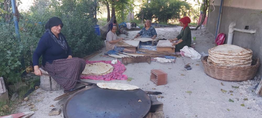 Osmanye'de sıcak hava şartlarına rağmen ateşin başında  yufka ekmek pişirme geleneğini sürdürüyorlar.